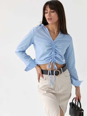 Укорочена блакитна блуза з кулісою вздовж пілочки | 6807576