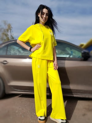 Трикотажний жовтий костюм-двійка: футболка і штани | 6827000
