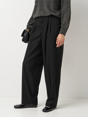 Чорні вільного крою штани із звуженими штанинами зі складками | 6865440