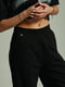 Черный брючный костюм: футболка и расклешенные брюки | 6845599 | фото 5