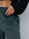 Велюровые расклешенные зеленые брюки на байке | 6853401 | фото 2